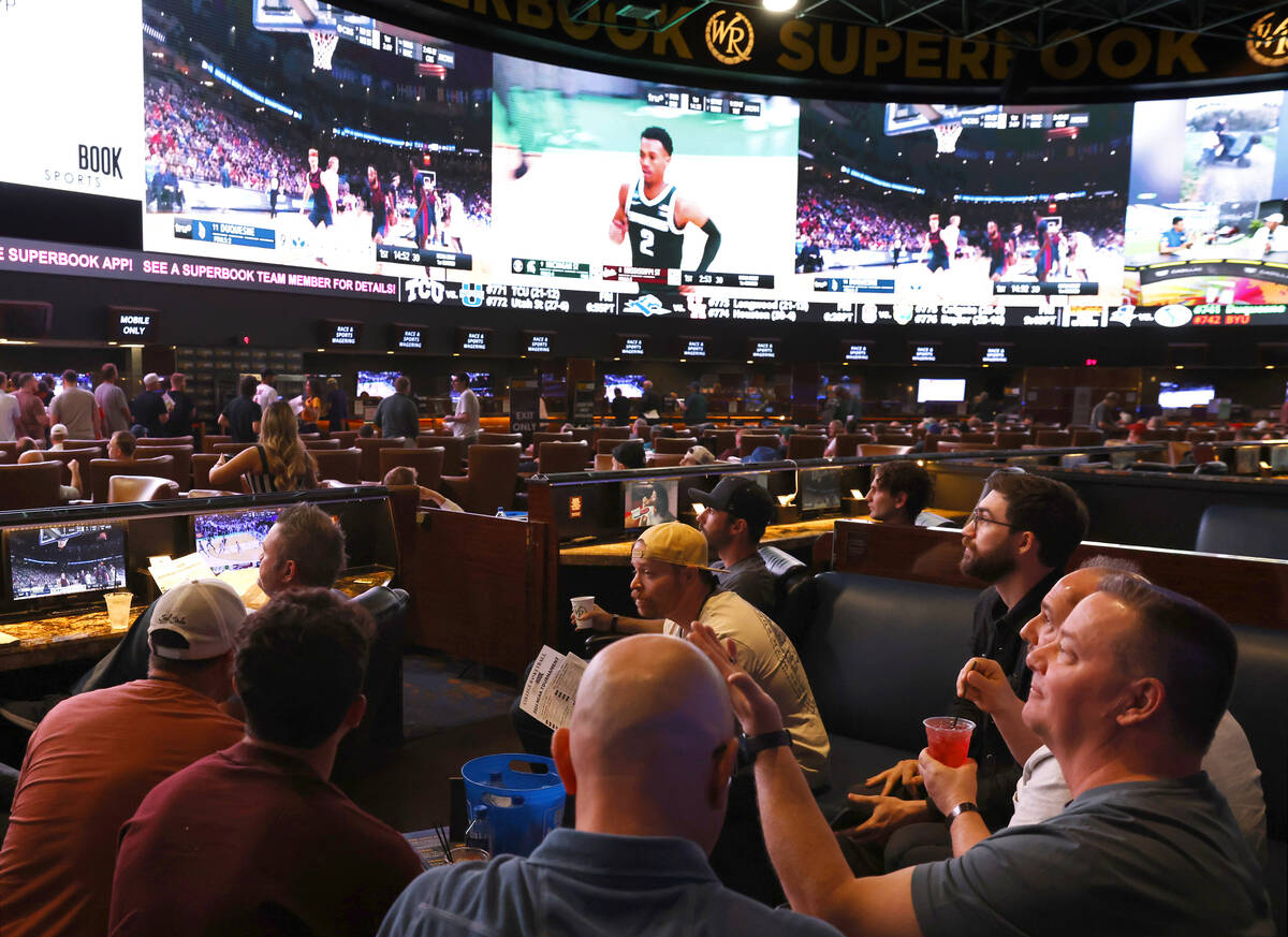 Guests watch on the big screens the first day of the NCAA basketball tournament at Westgate spo ...