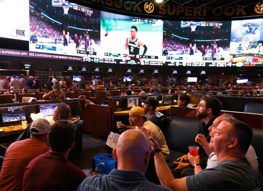 Guests watch on the big screens the first day of the NCAA basketball tournament at Westgate spo ...