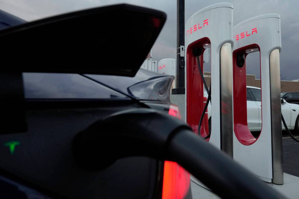 A vehicle charges at a Tesla Supercharger station in Detroit, Nov. 16, 2022. (AP Photo/Paul Sancya)