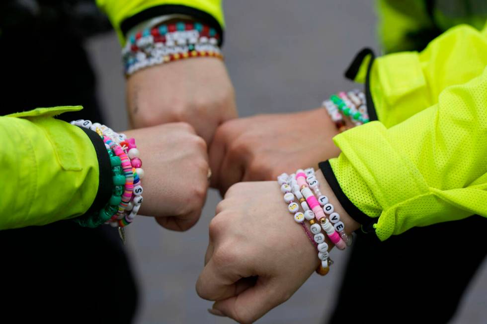 Four police officers show their wrist bands that have names of Swift songs as fans of singer Ta ...