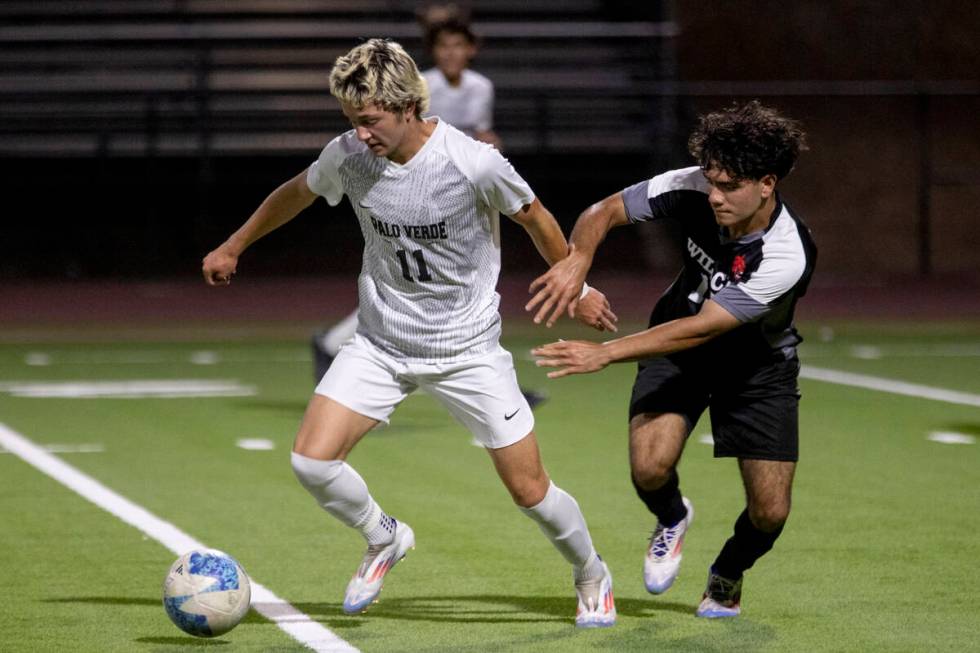 Palo Verde junior Noah Johnson (11) keeps the ball away from Las Vegas High senior Abraham Truj ...