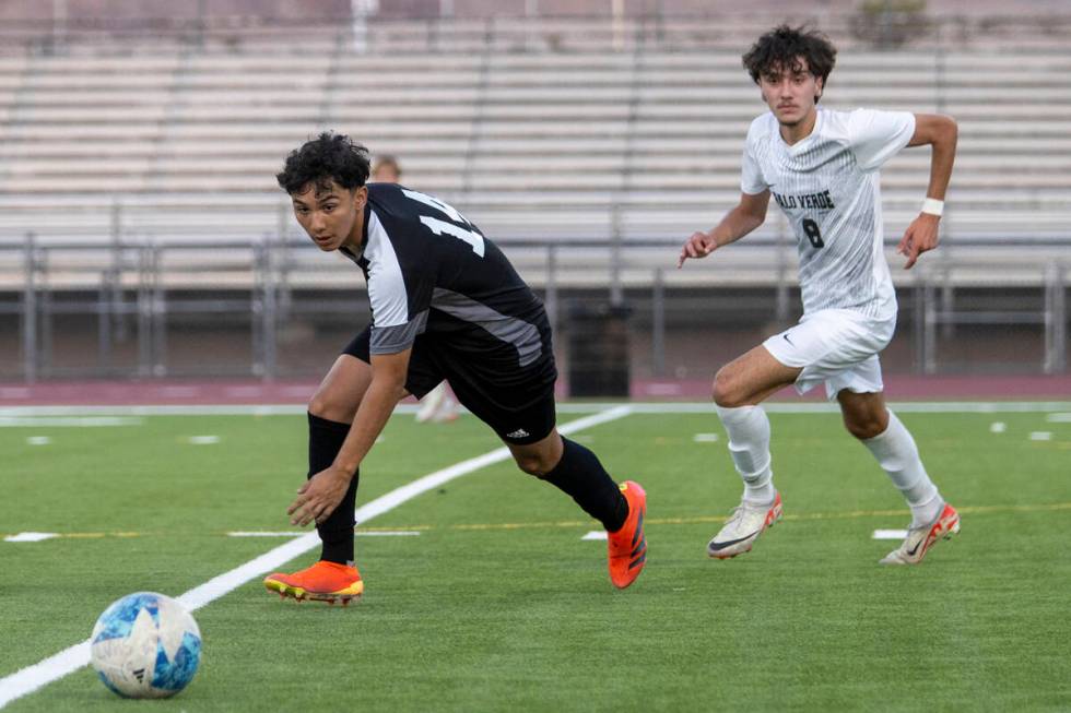 Las Vegas High junior Cesar Ruelas (14) and Palo Verde junior Josemartin Ospina (8) run after t ...