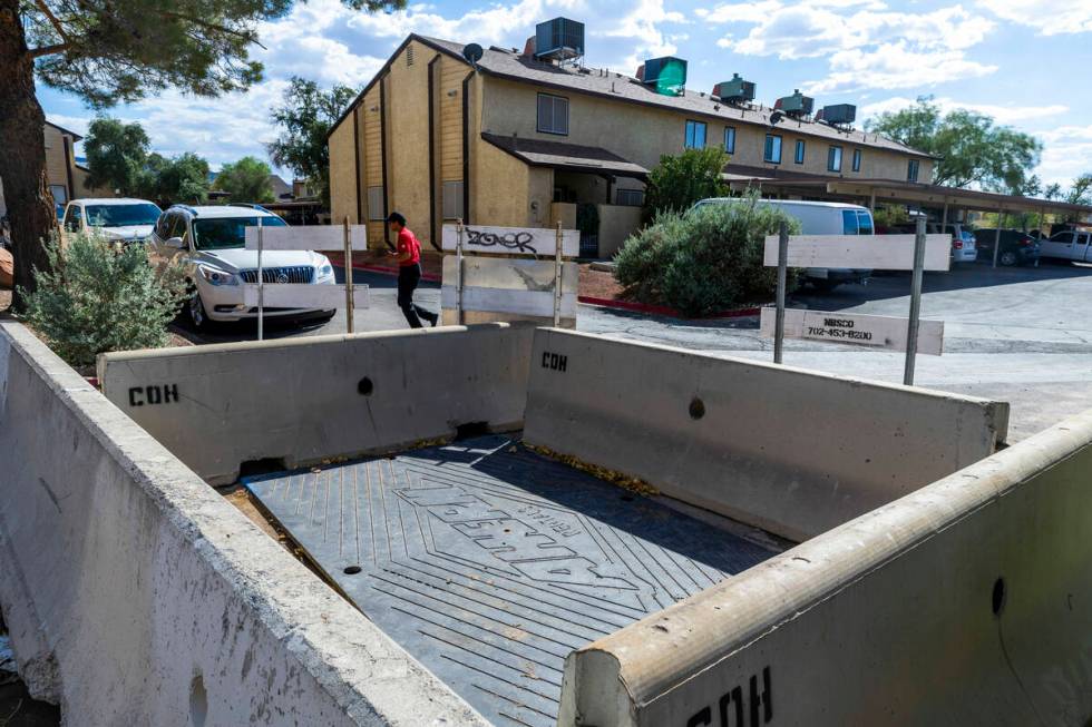 A resident walks around a barricaded area where seeping water caused a sinkhole in one of many ...