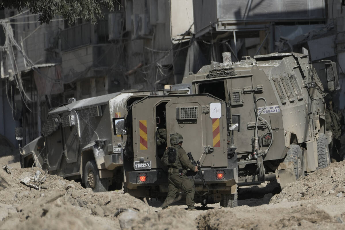 Members of Israeli forces patrol a street during a military operation in the West Bank refugee ...