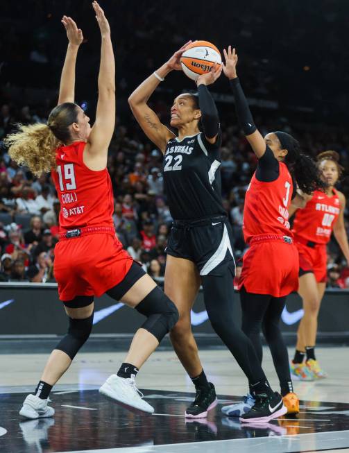 Aces center A'ja Wilson (22) fights to make a basket as Atlanta Dream forward Lorela Cubaj (19) ...