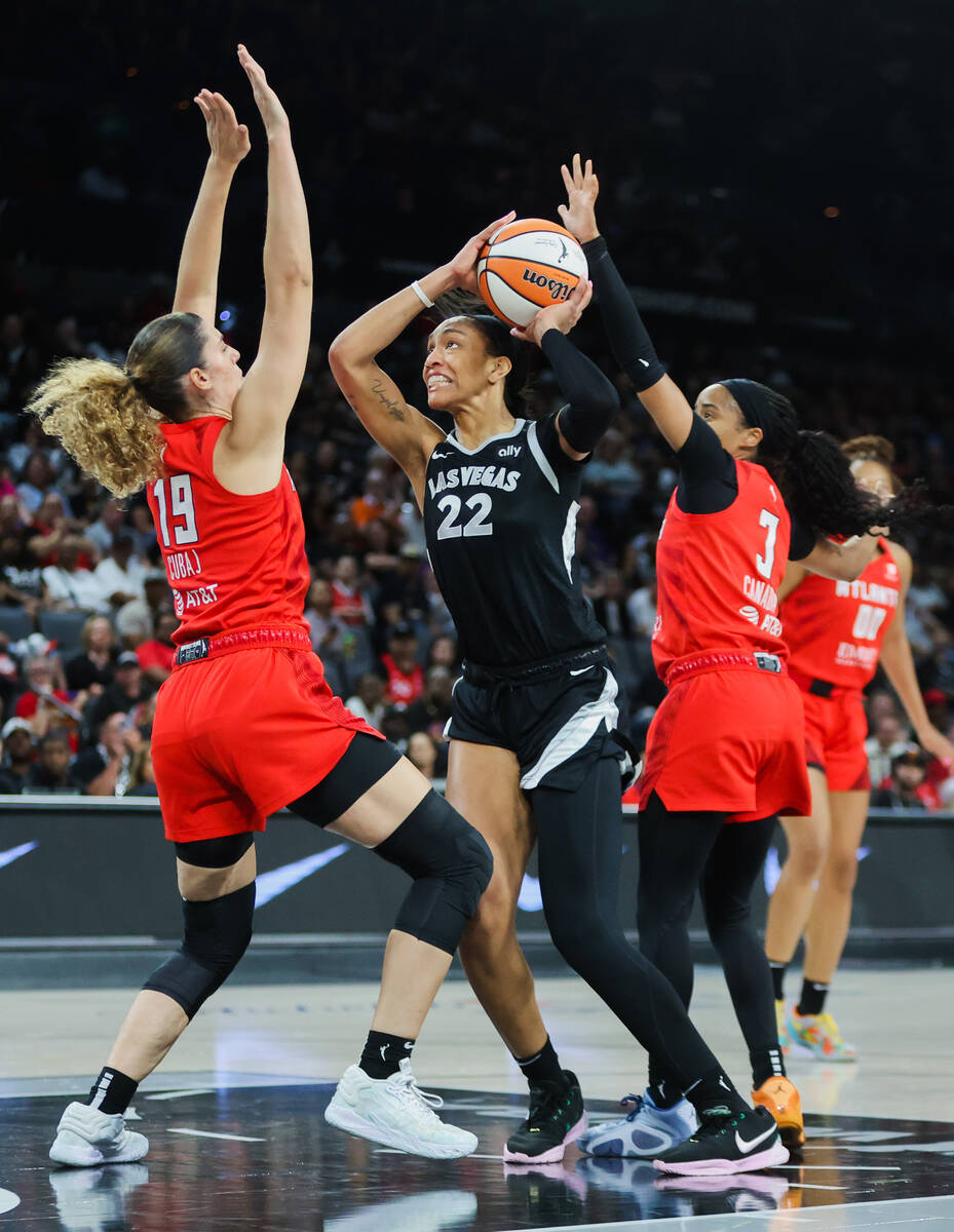 Aces center A'ja Wilson (22) fights to make a basket as Atlanta Dream forward Lorela Cubaj (19) ...