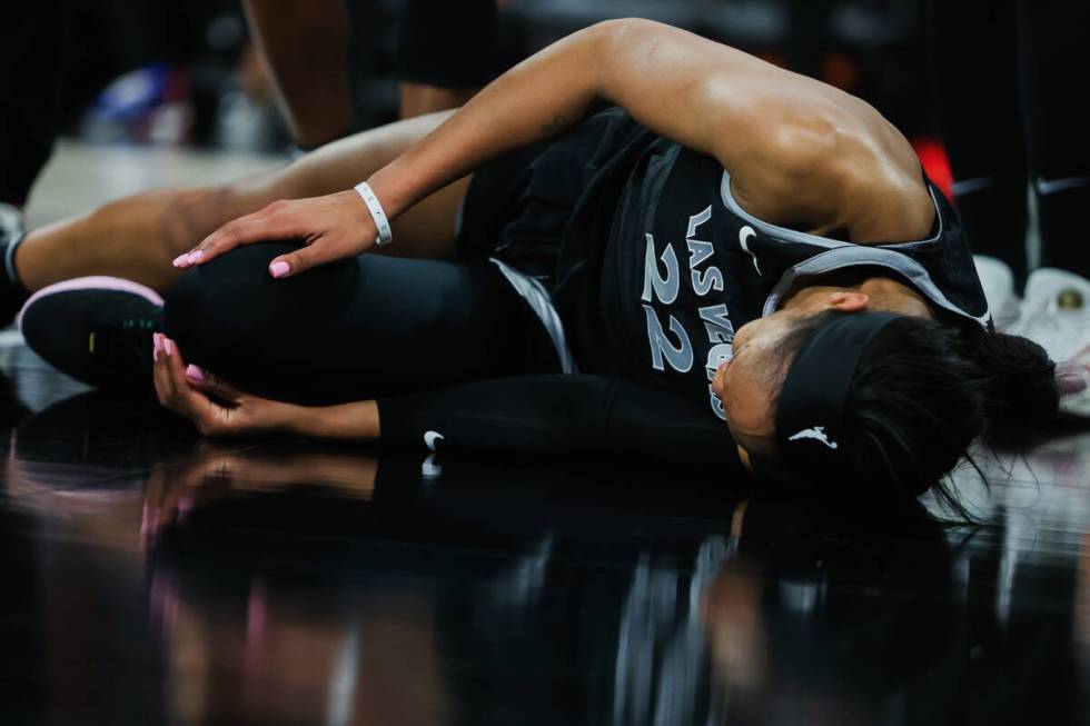 Aces center A'ja Wilson lays on the ground after inuring her leg during a WNBA basketball game ...