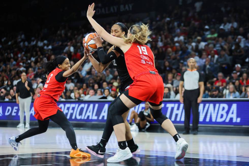 Aces center A'ja Wilson (22) fights through defense by Atlanta Dream guard Haley Jones (13) and ...