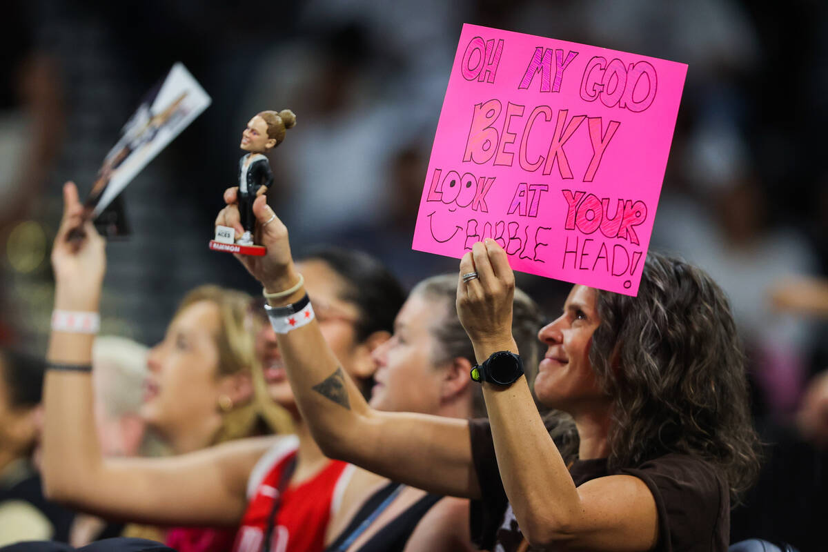 A fan shows off a Becky Hammon bobblehead during a WNBA basketball game between the Las Vegas A ...