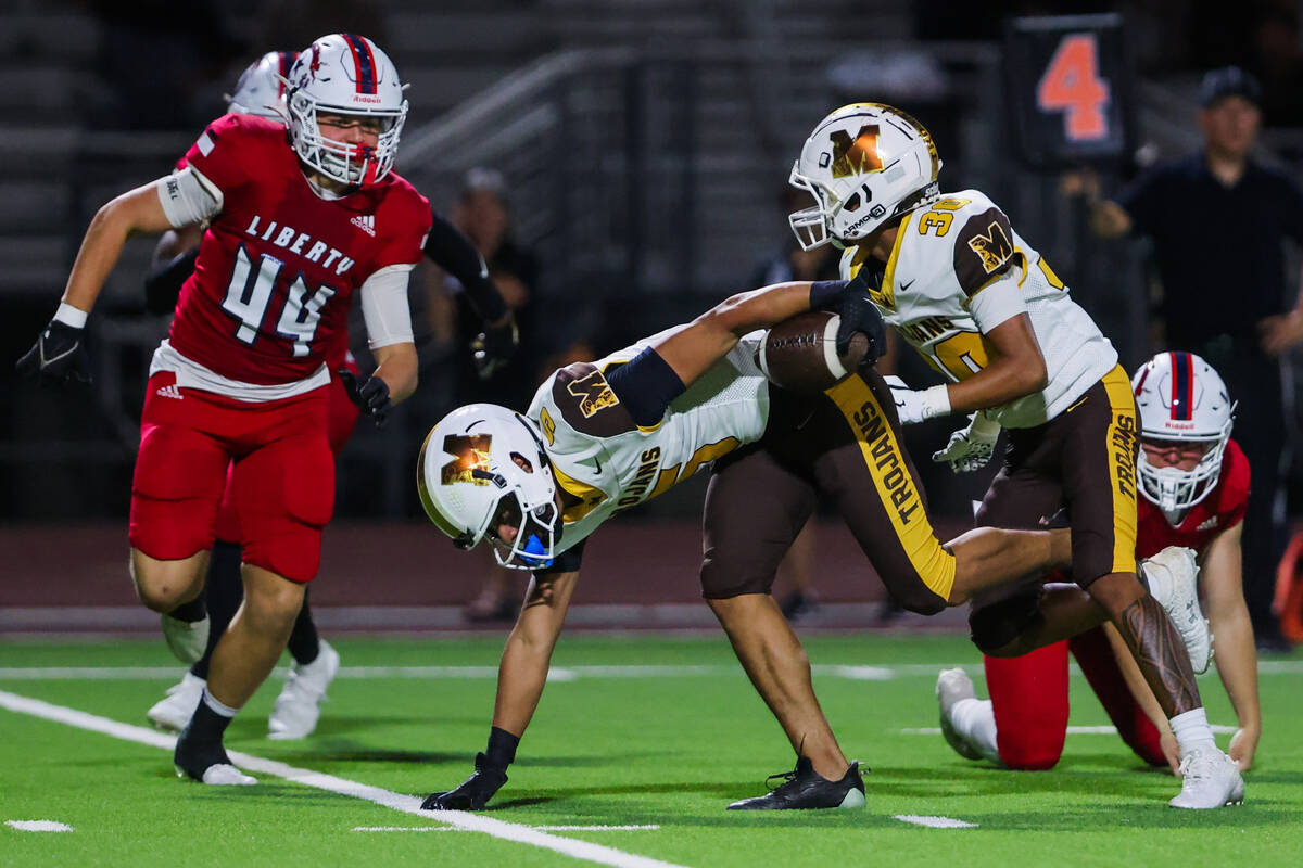 Mililani wide receiver Jonah Togafau-Tavui (5) falls to the ground after running the ball durin ...