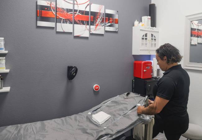 Owner Karen Garrett adjusts an infrared sauna body wrap at KG Recovery Lounge. (Rachel Aston/La ...