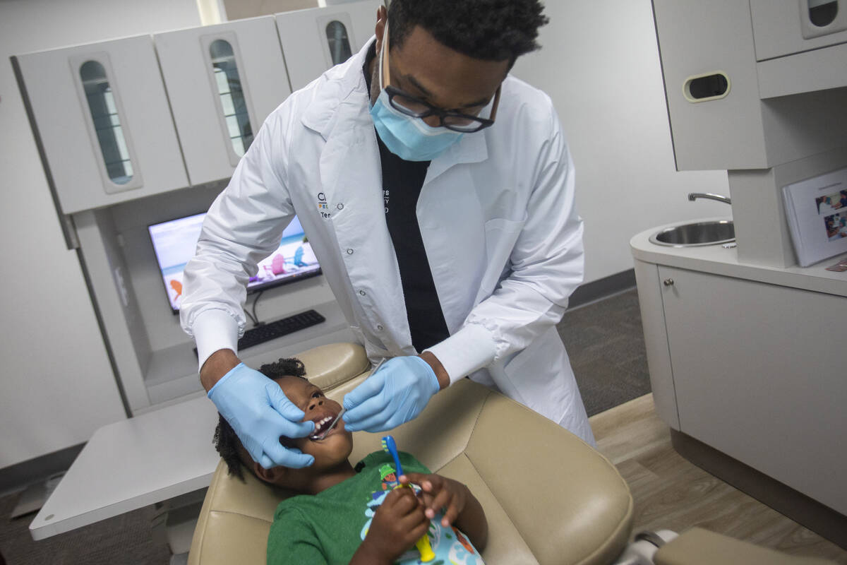 Dentist Terry Meads looks at the teeth of Sammy Hale, 4, at Changing Smiles Pediatric Dentistry ...