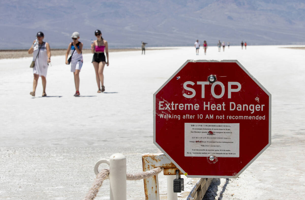 FILE - A stop sign warns tourists of extreme heat at Badwater Basin, Monday, July 8, 2024, in D ...