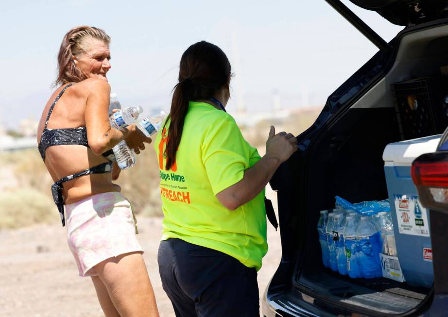 Jaqualyne Peeples, a Help of Southern Nevada outreach worker, delivers water to Tamara Christia ...