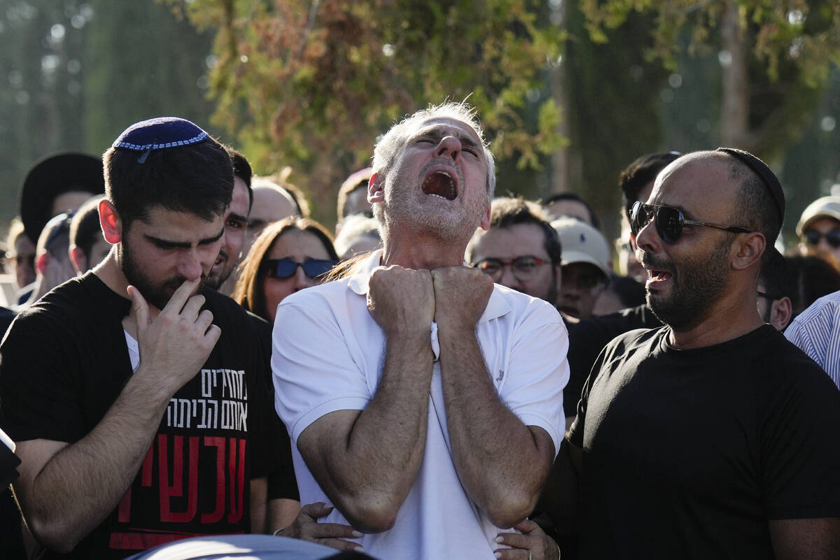 Yigal Sarusi, center, mourns during the funeral of his son, slain hostage Almog Sarusi, who was ...