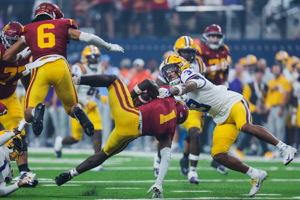 Southern California wide receiver Zachariah Branch (1) goes down with the ball as LSU wide rece ...