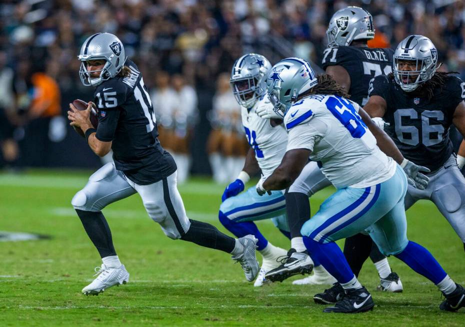 Raiders quarterback Gardner Minshew (15) looks for yardage after flushed from the pocked by Dal ...