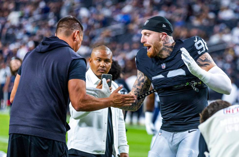 Raiders defensive end Maxx Crosby (98) gets pumped up with a coach during warm ups before the f ...