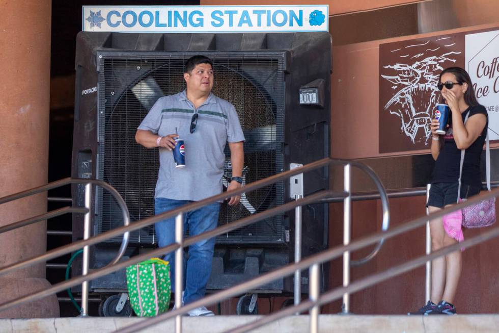 Tourists stand in the shade near a large cooling station fan at the Hoover Dam Friday, July 5, ...