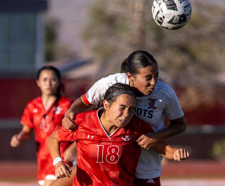 Arbor View freshman Mai Ly Hayes (18) and Liberty defender Nai'a Pomaikai (16) compete for the ...