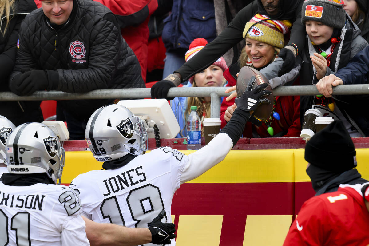 Las Vegas Raiders cornerback Jack Jones (18) gives the ball to fans after scoring a touchdown o ...