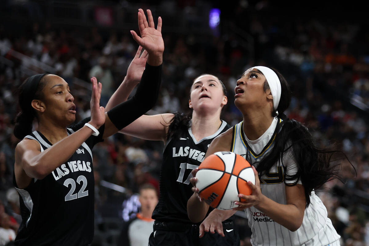 Chicago Sky forward Angel Reese, right, shoots against Las Vegas Aces center A'ja Wilson (22) a ...