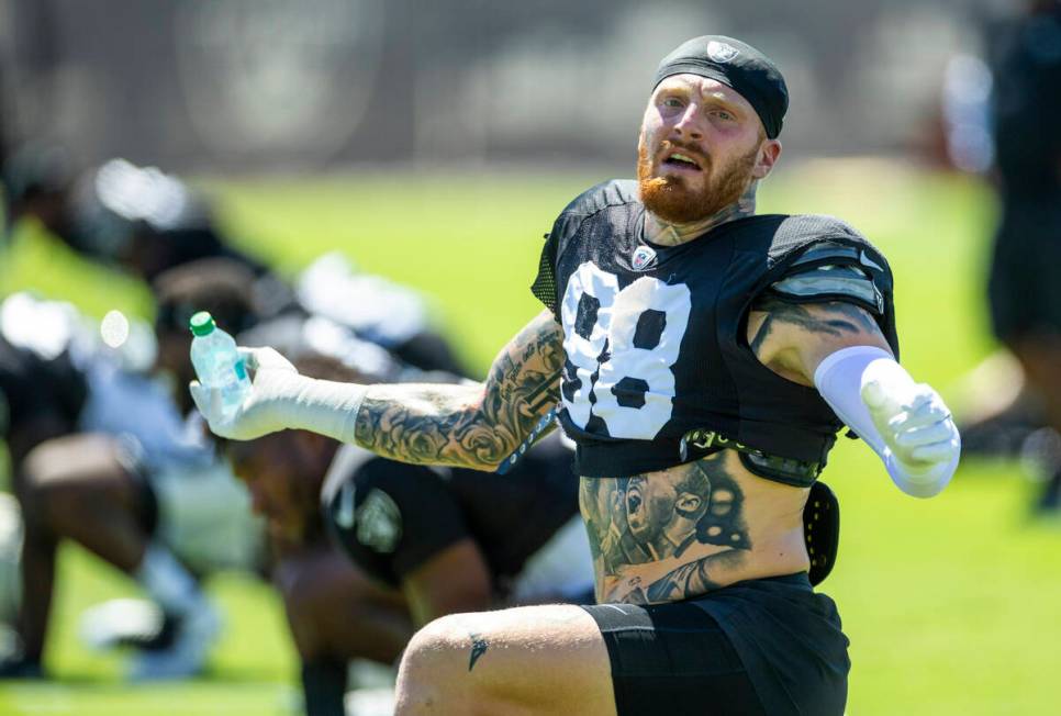 Raiders defensive end Max Crosby (98) stretches with teammates during practice at the Intermoun ...