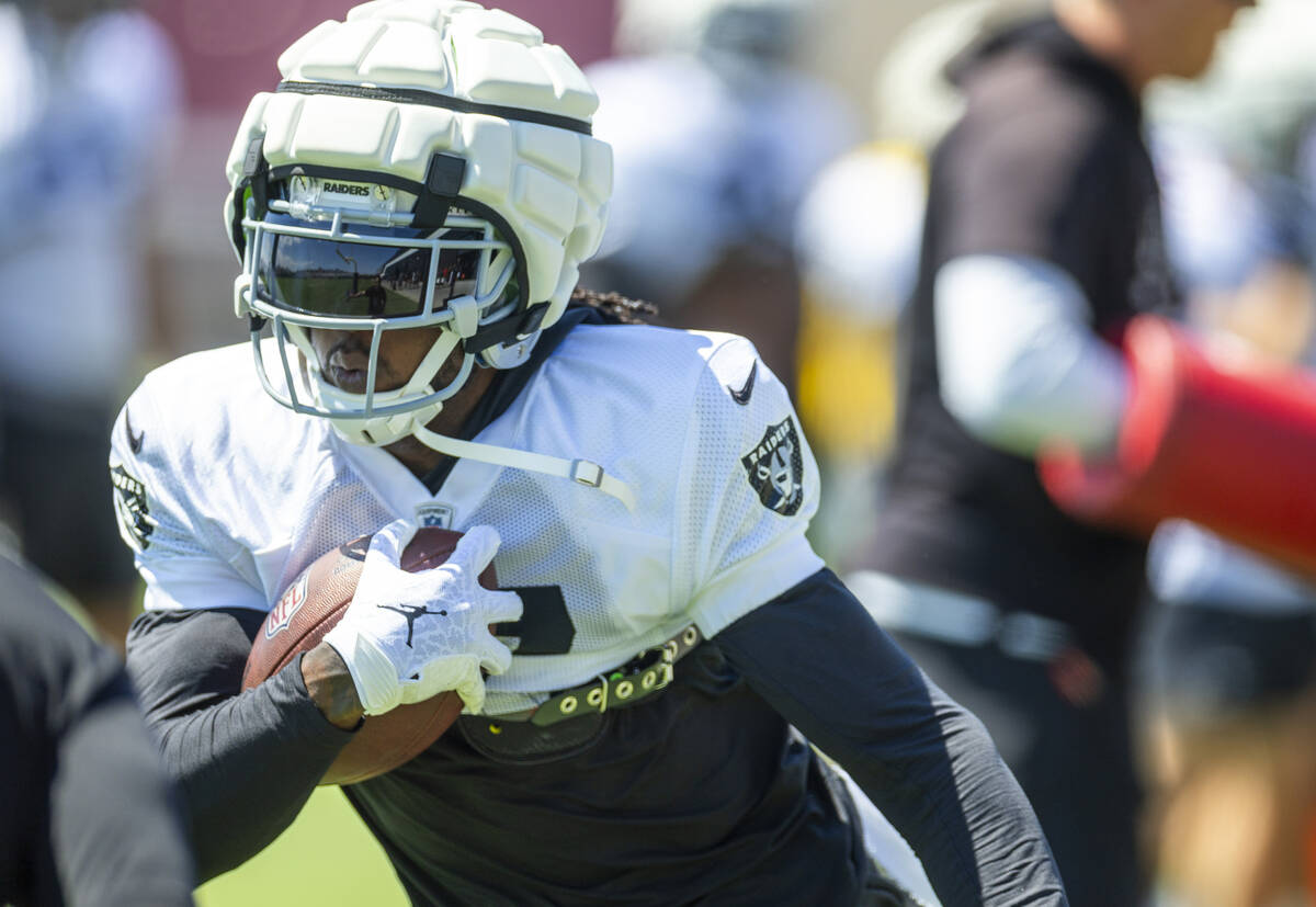 Raiders wide receiver Davante Adams (17) cuts with the ball on a run during practice at the Int ...