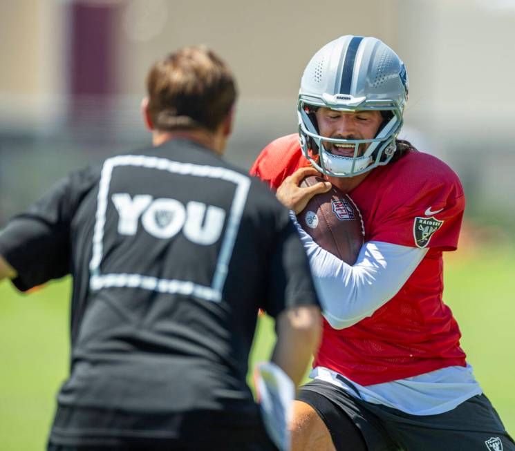 Raiders quarterback Gardner Minshew (15) makes a cut with the ball on a run during a drill in p ...