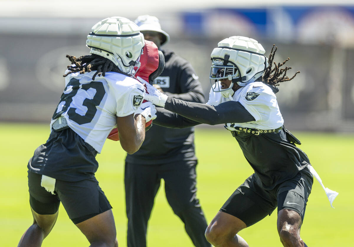 Raiders wide receiver Kristian Wilkerson (83) holds a pad as wide receiver Davante Adams (17) s ...