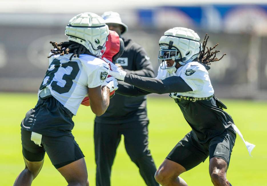 Raiders wide receiver Kristian Wilkerson (83) holds a pad as wide receiver Davante Adams (17) s ...