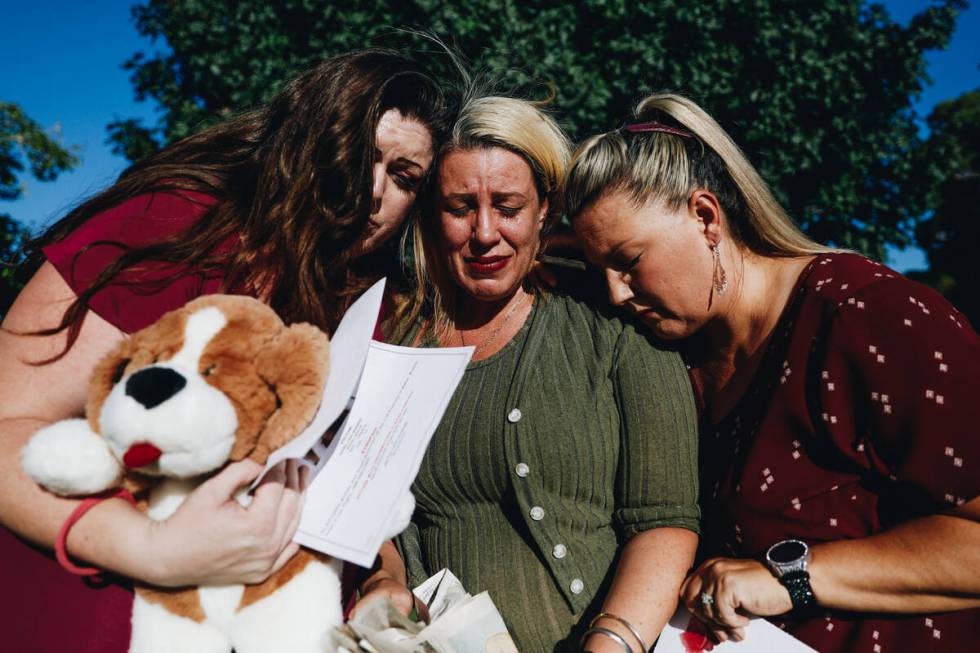 Danielle Wingett, middle, cries as Nathalie Walker, left, and Velvette Williams comfort her whi ...