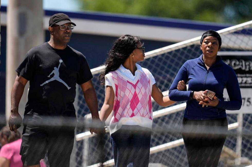 Parents walk their child out of Apalachee High School after a shooting at the school Wednesday, ...