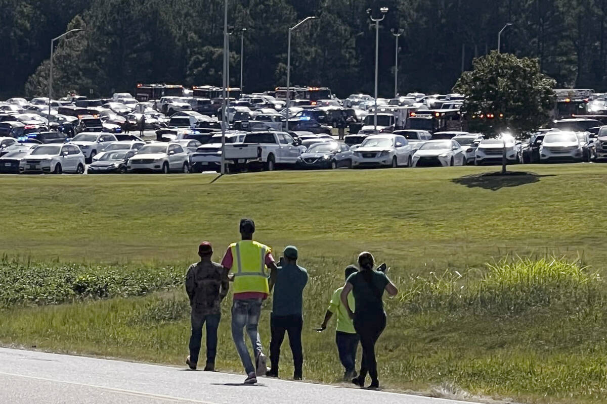 Students are evacuated to the football stadium after the school campus was placed on lockdown a ...