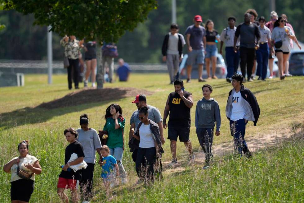 Students and parents walk off campus at Apalachee High School, Wednesday, Sept. 4, 2024, in Win ...