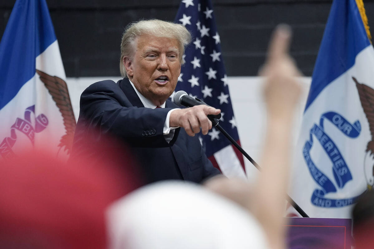 Former President Donald Trump visits with campaign volunteers. (AP Photo/Charlie Neibergall)