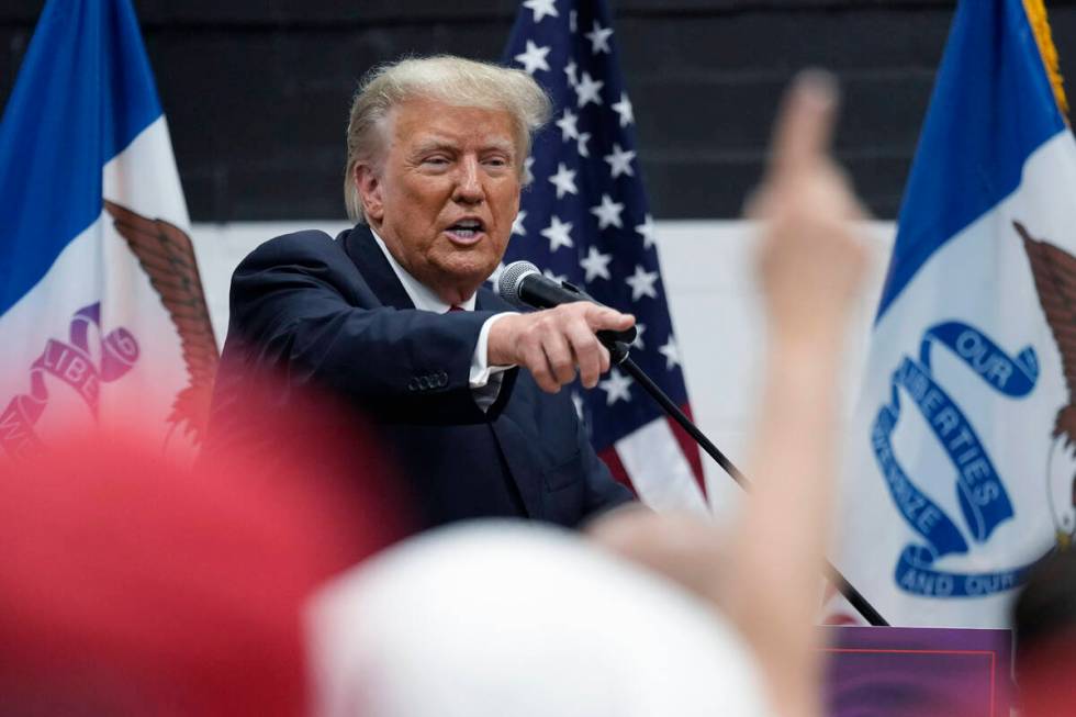 Former President Donald Trump visits with campaign volunteers. (AP Photo/Charlie Neibergall)