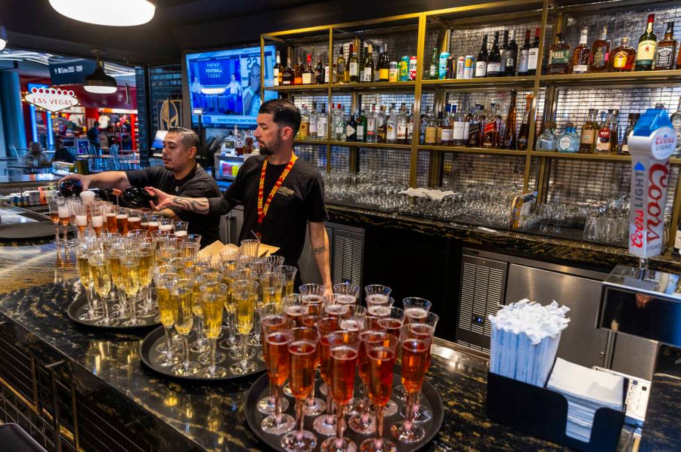 Bartenders put dinks for guests to sample during the grand opening celebration for the Vegas Bo ...