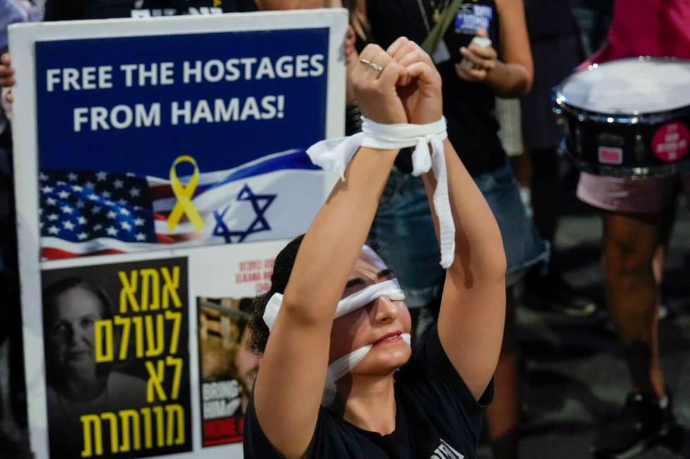 A woman wears a blindfold during a protest calling for a cease-fire deal and the immediate rele ...