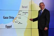 Israeli Prime Minister Benjamin Netanyahu gestures in front of a map during a press conference ...