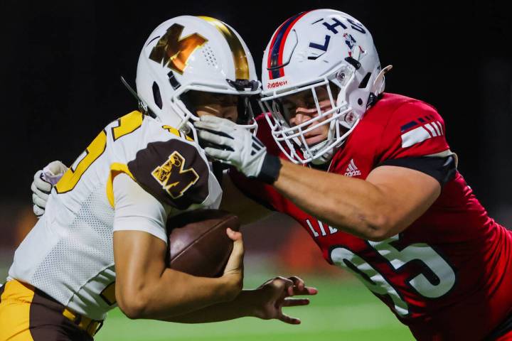 Mililani quarterback Kekoa Koong (16) braces for impact as Liberty defensive lineman Derek Jone ...