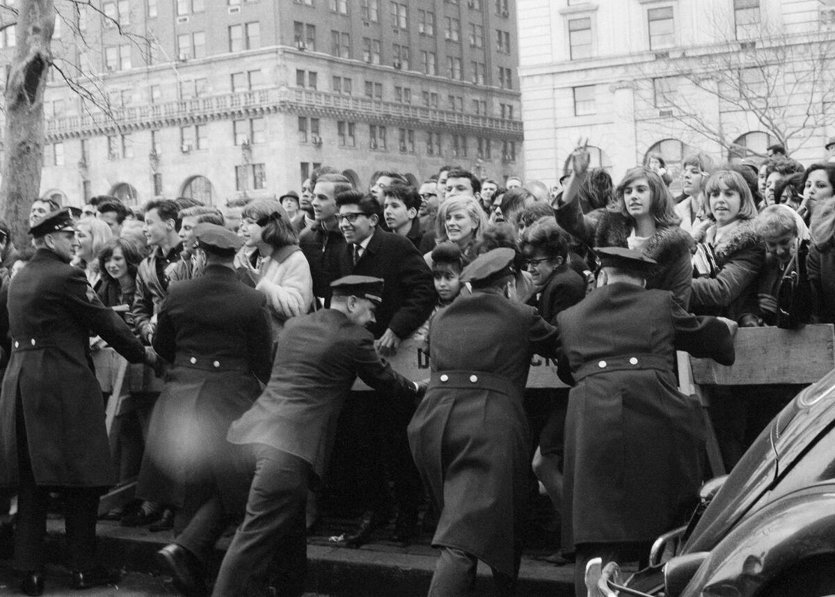 Young fans cheer the arrival of the Beatles at New York City's Plaza Hotel on Feb. 7, 1964. Amo ...