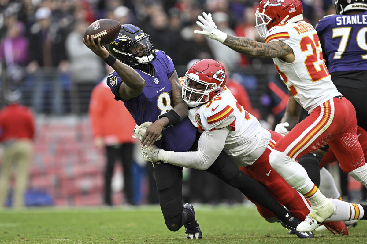 Baltimore Ravens quarterback Lamar Jackson (8) is pressured by Kansas City Chiefs defensive tac ...