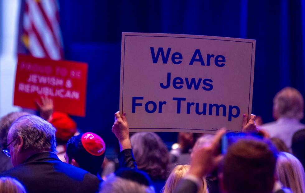 Signs are held up by attendees during the Republican Jewish Coalition’s annual leadershi ...