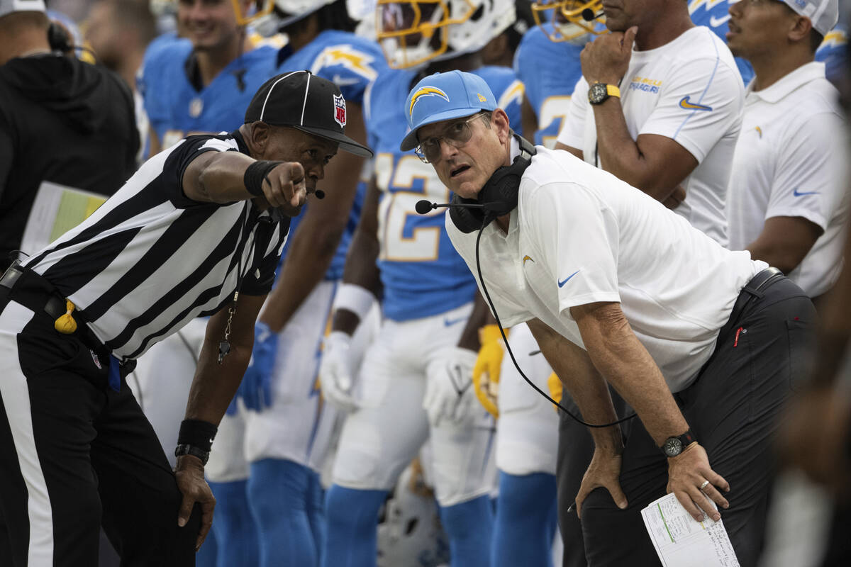 Los Angeles Chargers head coach Jim Harbaugh talks to a referee during an NFL preseason footbal ...