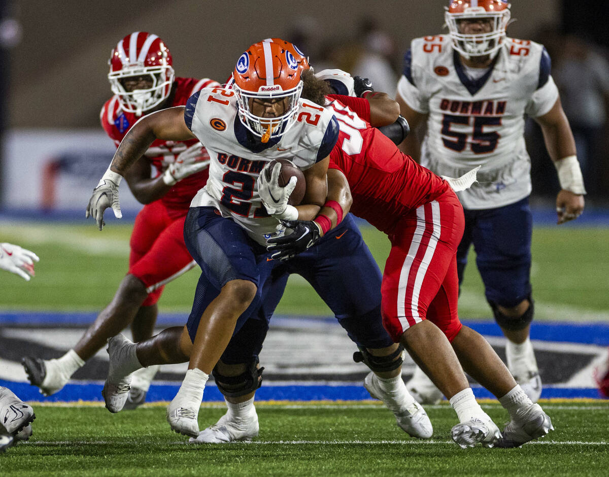 Bishop Gorman running back Jonathan Coar (21) battles for more yards against Mater Dei during t ...