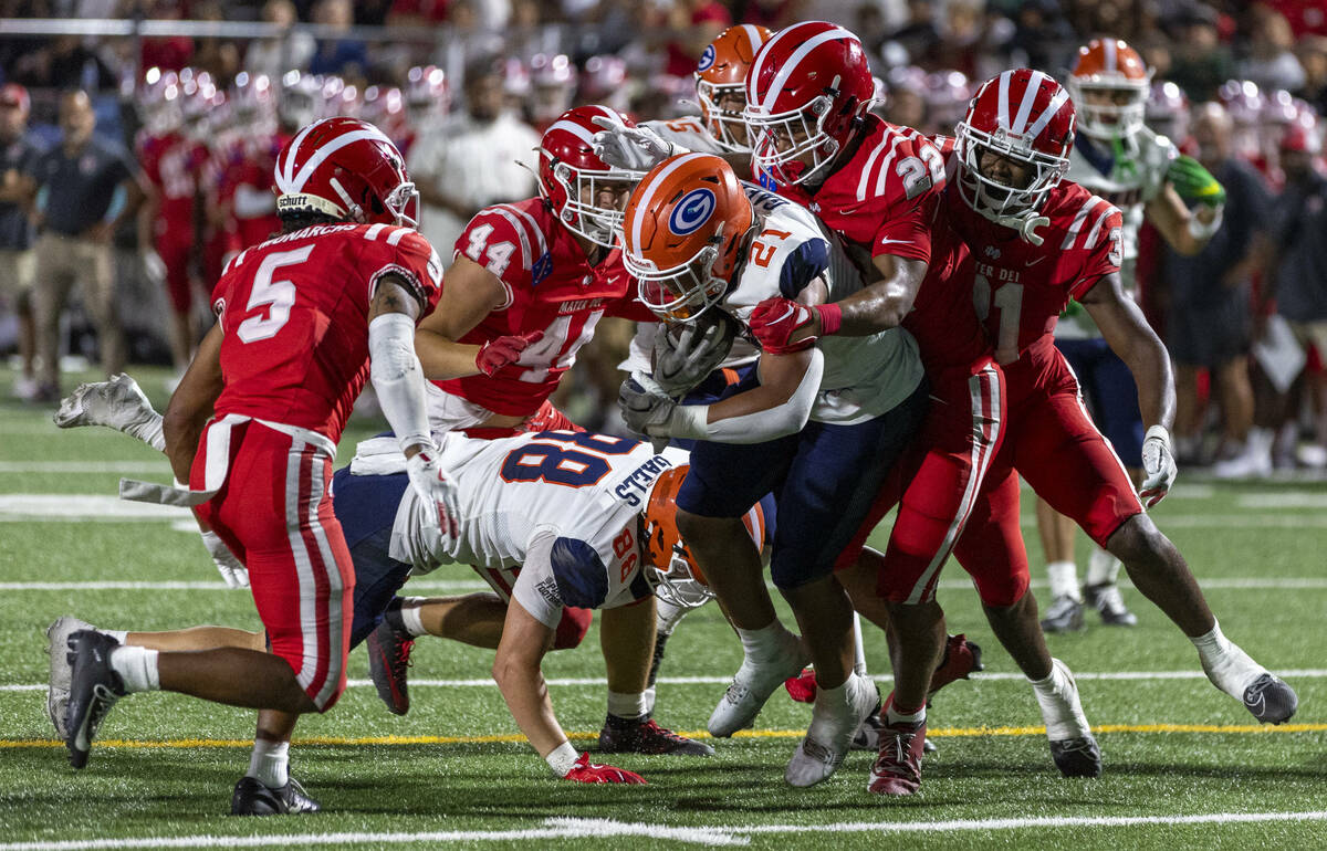 Bishop Gorman running back Jonathan Coar (21) battles for more yards near the end zone against ...