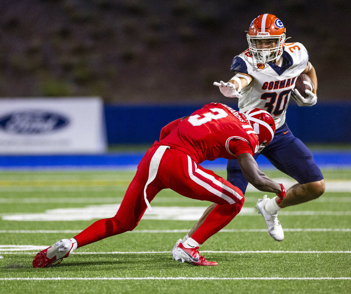 Bishop Gorman wide receiver Derek Meadows (30) looks to fend off Mater Dei defensive back Chuck ...