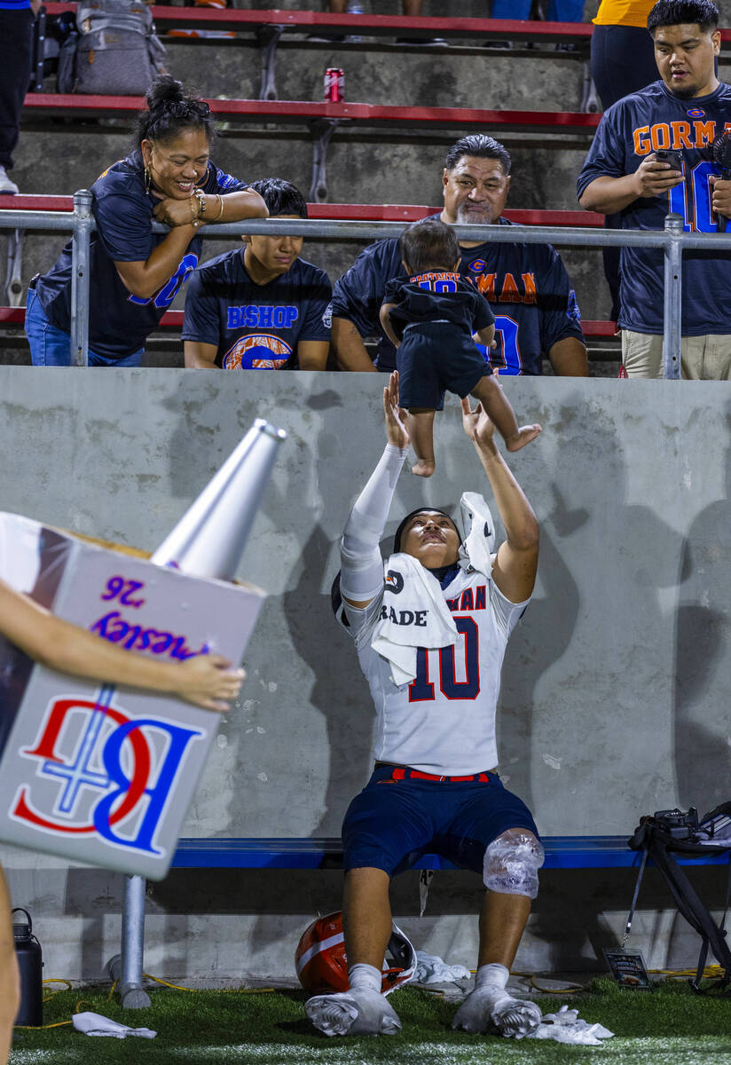 Bishop Gorman linebacker Tamatoa Gaoteote (10) tosses Semaia, 9 mos., as he sits on the bench w ...