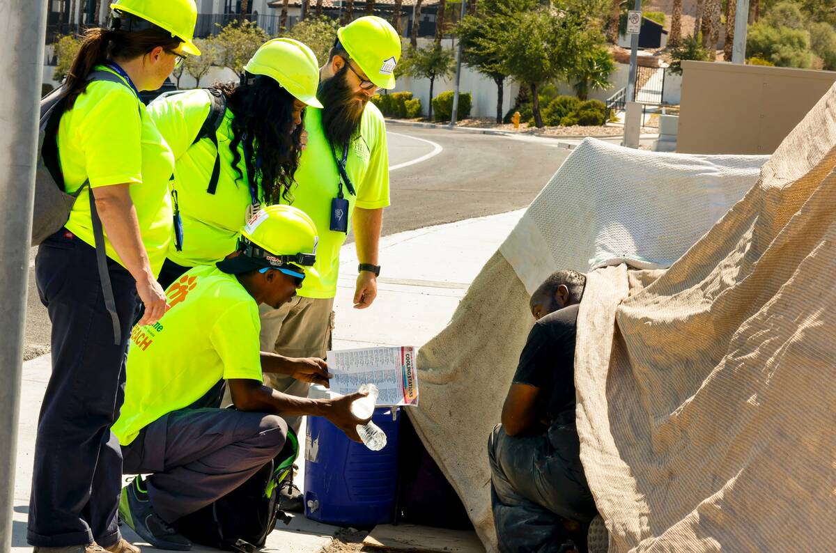 Help of Southern Nevada outreach workers talk to Darryl Walker, right, a homeless person, near ...